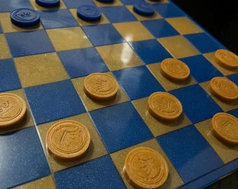 Blue and gold handmade resin checker set. Comes with 24 pieces, a board,  and a carrying bag.