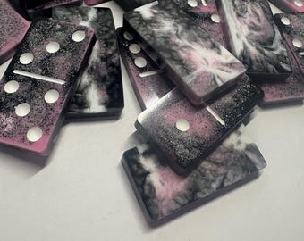 Black, pink, and white handmade resin Dominoes.