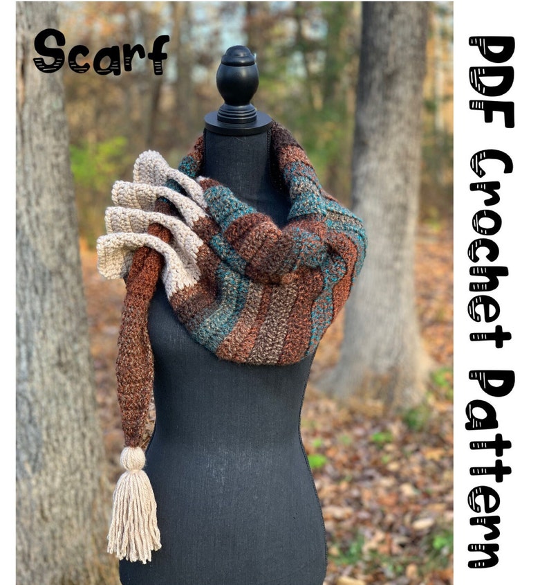 May include: A crocheted scarf with a brown, teal, and beige color scheme. The scarf has a long tassel and is displayed on a black mannequin. The text "Scarf" is at the top of the image and "PDF Crochet Pattern" is on the right side of the image.