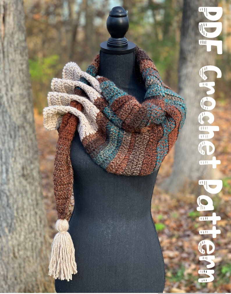 May include: A crocheted scarf with a long tassel, featuring brown, beige, and teal stripes. The scarf is draped over a black mannequin. The text "PDF Crochet Pattern" is written in white on a white background in the upper right corner of the image.