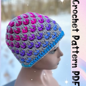 Puede incluir: Un gorro de crochet gris con un diseño degradado de colores en rosa, morado y azul. El gorro lo lleva puesto una persona y el texto "Crochet Pattern PDF" es visible en el fondo.