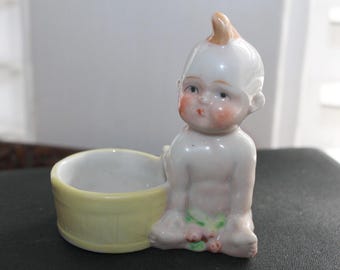 Antique Kewpie Porcelain Figurine with Yellow Basket & Pink Flowers –  Former pin cushion, small object holder, Kewpie Doll figurine