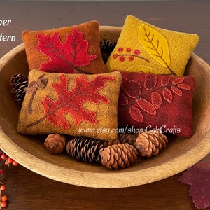 May include: Four felt leaf-shaped pillows in a wooden bowl. The pillows are in shades of red, orange, and yellow. The text "Paper Pattern" is visible in the top left corner of the image.