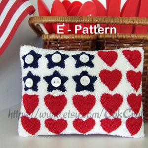 May include: A white pillow with a red, white, and blue patriotic design. The pillow features a row of red hearts and a row of blue stars with white buttons in the center of each star. The text "E-Pattern" is visible above the pillow.
