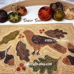 May include: A handcrafted rug with a bird and leaf design, featuring brown, green, and tan hues. The rug is surrounded by various yarn skeins in complementary colors. The words "Paper Pattern" and "©2025 Carla Klapka cgkcrafts.etsy.com" are visible.