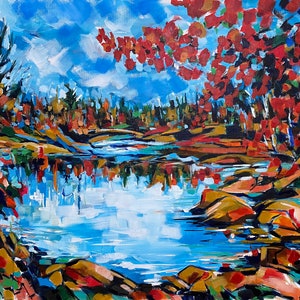 May include: A painting of a lake scene with fall foliage in shades of red, orange, and yellow. The lake is a bright blue with reflections of the trees. The trees are on the banks of the lake and in the background.