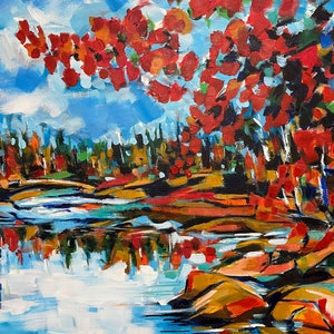 May include: A painting of a lake scene with a bright blue sky and red, orange, and yellow trees reflected in the water. The trees are on the right side of the painting, and the lake is in the foreground.