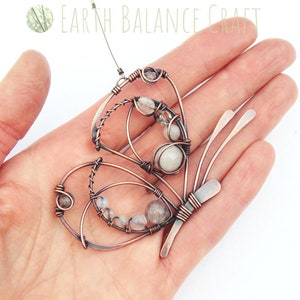 K&ouml;nnte beinhalten: Kupferdraht-Schmetterling mit wei&szlig;en Edelstein-Akzenten. Der Schmetterling ist handgefertigt und hat ein zartes, filigranes Design.