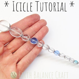 May include: A close-up of a crystal icicle ornament made with clear and blue glass beads strung on silver wire. The icicle is held in a hand against a white background. The text *ICICLE TUTORIAL* is at the top of the image.