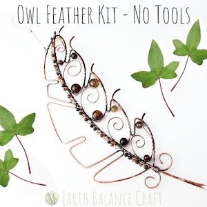 May include: A copper wire owl feather kit with brown beads and decorative swirls. The text "OWL FEATHER KIT - NO TOOLS" is at the top. Green ivy leaves are scattered around the feather on a white background. The Earth Balance Craft logo is at the bottom.
