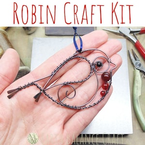 May include: A wire craft kit to make a robin ornament. The kit includes copper wire, red beads, and instructions. The finished ornament is shown in the image, with the robin's body made of wire and the breast decorated with red beads.