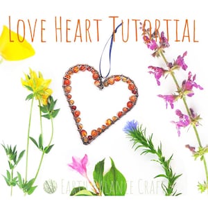 May include: A wire heart-shaped frame with orange and brown stones, surrounded by various flowers and greenery. The text "LOVE HEART TUTORIAL" is at the top of the image.