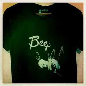 May include: Black v-neck t-shirt with the word "Beep" in white script and a stylized insect graphic. The shirt has a tag that reads "BE ACTIVE".