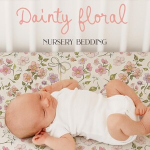 Puede incluir: Una s&aacute;bana de cuna blanca con un estampado floral rosa y verde. La s&aacute;bana presenta un delicado dise&ntilde;o floral con flores rosas y moradas, hojas verdes y lazos blancos. La s&aacute;bana est&aacute; hecha de tela suave y transpirable, perfecta para la habitaci&oacute;n de un beb&eacute;.