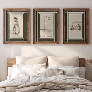 May include: Three framed golf-themed prints. Each print has a cream-colored background with a black and white illustration. The frames are a dark wood color with a green and white border. The prints depict golf clubs, a flag on the green, and a golf cart.