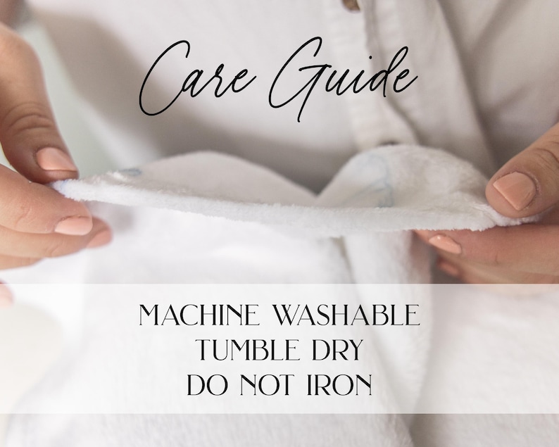 Puede incluir: Primer plano de una tela blanca y esponjosa sostenida por manos con u&ntilde;as cuidadas. El texto "Care Guide" est&aacute; escrito en cursiva en la parte superior. Debajo, el texto dice "MACHINE WASHABLE, TUMBLE DRY, DO NOT IRON."