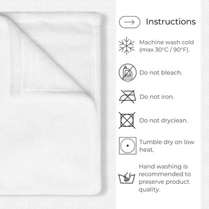 May include: White blanket with care instructions. The instructions include: machine wash cold (max 30&deg;C / 90&deg;F), do not bleach, do not iron, do not dry clean, tumble dry on low heat, and hand washing is recommended.
