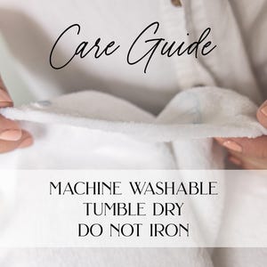 May include: A close-up of a white fabric being held by hands. The text "Care Guide" is written in cursive at the top. Below, the text reads "MACHINE WASHABLE, TUMBLE DRY, DO NOT IRON."