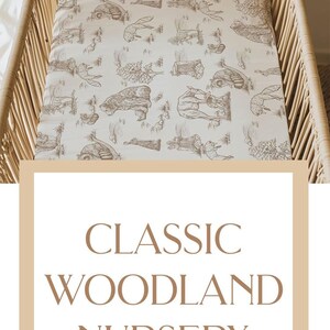 May include: A crib sheet and blanket set with a woodland animal theme. The blanket is cream-colored with a brown animal print and the name "Michael James". The crib sheet has a matching animal print.