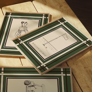 May include: Three framed golf-themed prints with green and white borders. The prints feature sketches of golf equipment and scenes, including a golf bag with clubs, a flag on the green, and a golf cart. The text "WILLIAM GEORGE" is visible on one print.