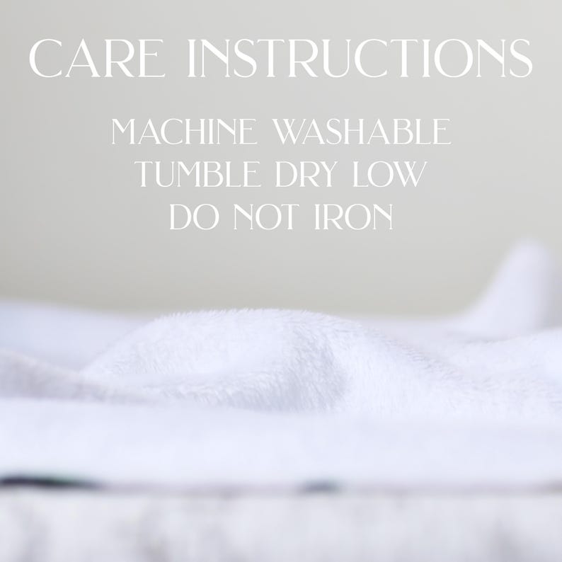 May include: White, fluffy fabric with the words "CARE INSTRUCTIONS" at the top. Below, the text reads "MACHINE WASHABLE, TUMBLE DRY LOW, DO NOT IRON."