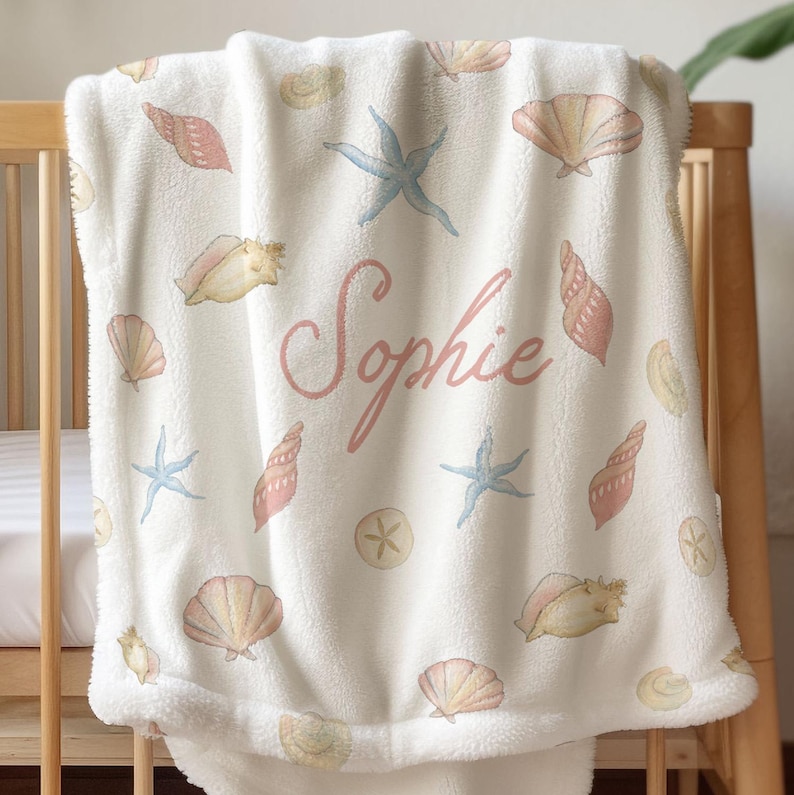 Personalized seashell baby blanket featuring baby girl’s name, soft plush fabric with ocean-themed design, ideal for nursery bedding. Personalized Girl Name Blanket Seashell Baby Gift Custom Name Blanket Kid Throw Blanket Girl Beach Party Gift Personalized Blanket Baby Girl