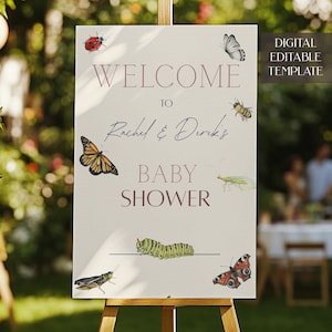 May include: A white welcome sign with pink text that reads "Welcome to Rachel & Derek's Baby Shower". The sign is decorated with illustrations of butterflies, ladybugs, caterpillars, and other insects.