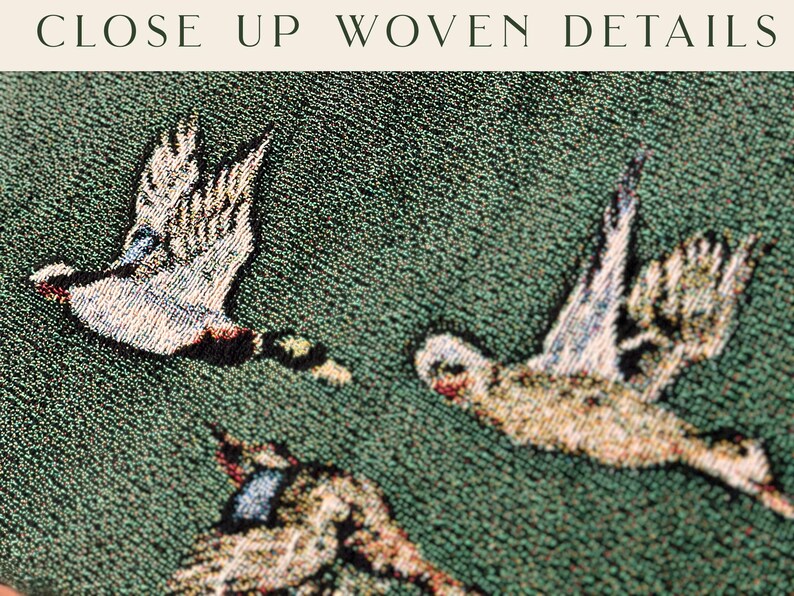 May include: Close-up of a tapestry with a green background and three white birds woven into the fabric. The birds are flying in different directions and have detailed features.