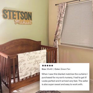 Puede incluir: Una cuna de madera con una manta beige y blanca con un paisaje des&eacute;rtico y el nombre "Stetson". Encima de la cuna hay un letrero de madera con el nombre "Stetson" y el nombre "Michael". La manta mide 76x102 cm.