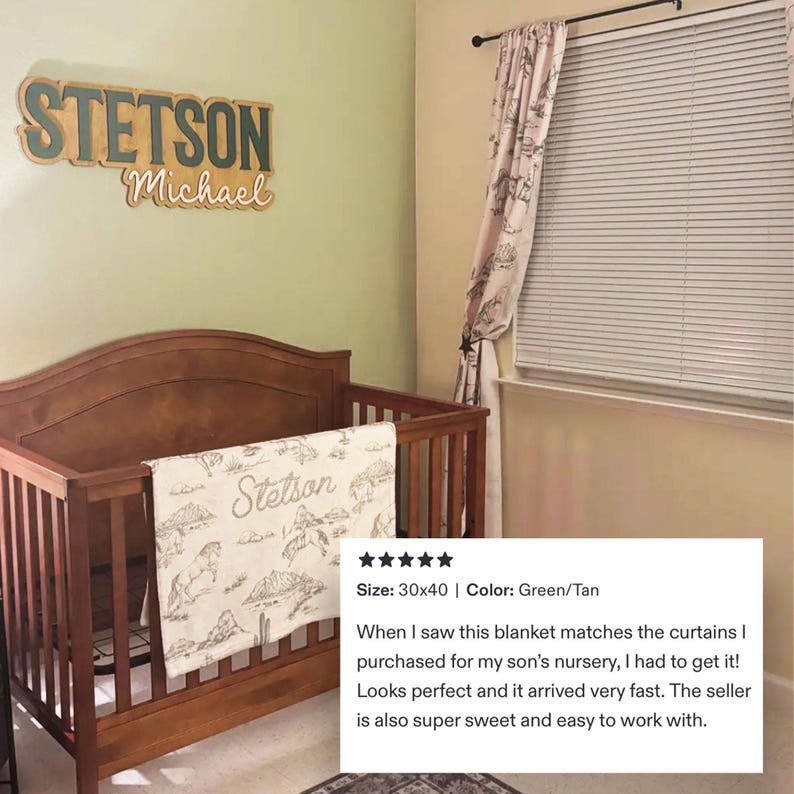 Puede incluir: Una cuna de madera con una manta beige y blanca con un paisaje des&eacute;rtico y el nombre "Stetson". Encima de la cuna hay un letrero de madera con el nombre "Stetson" y el nombre "Michael". La manta mide 76x102 cm.