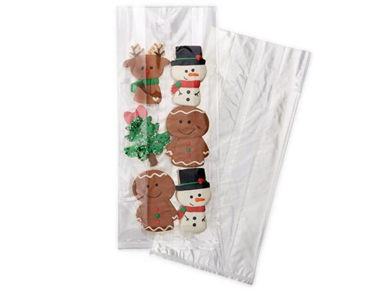 May include: Clear cellophane bag filled with Christmas-themed cookies. The cookies include a reindeer, snowman, gingerbread man, and Christmas tree. The cookies are decorated with colorful icing and placed in a clear bag.