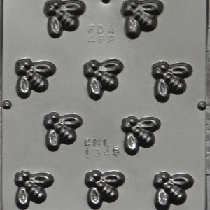 May include: A gray plastic mold with nine bee-shaped cavities. The mold has the text "FDA APP" and "CML 1345" printed on it.