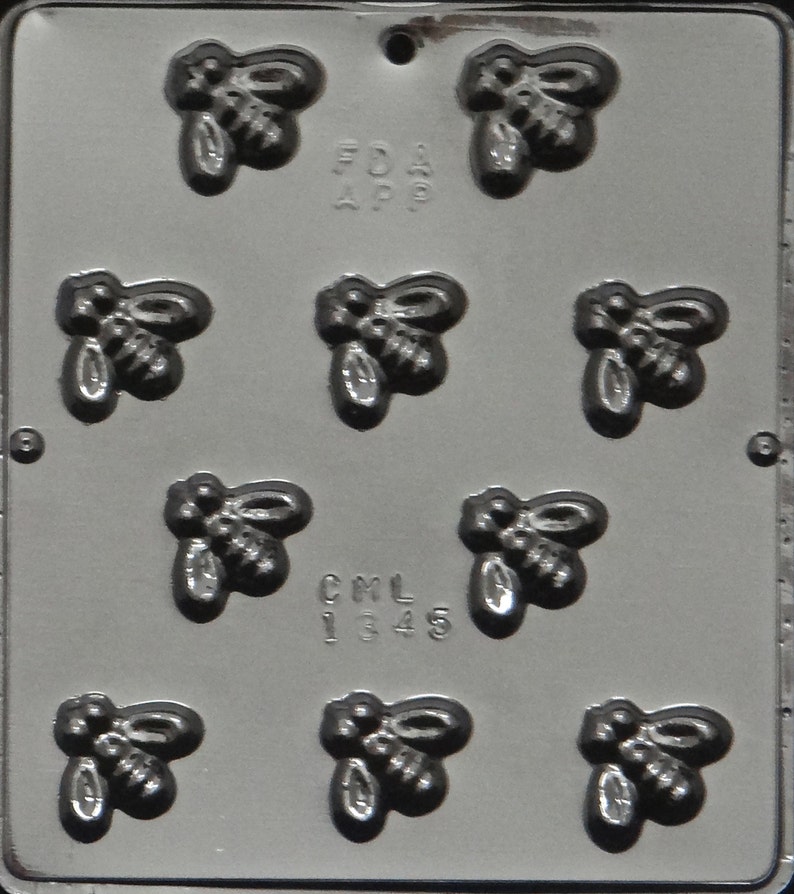 May include: A gray plastic mold with nine bee-shaped cavities. The mold has the text "FDA APP" and "CML 1345" printed on it.