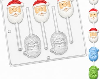 May include: A clear plastic candy mold tray featuring three cavities shaped like Santa Claus faces with attached stick channels. To the right, a vertical stack of five finished Santa lollipops in red, white, blue, and green colors is displayed.