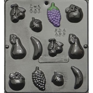 May include: A gray plastic mold with 10 cavities for making chocolate fruit shapes. The mold features grapes, pears, bananas, and cherries. The mold is labeled "CMA 531" and "FDA APP".