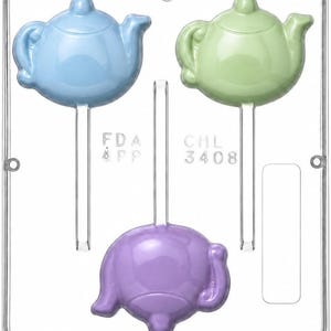 May include: A clear plastic candy mold featuring three teapot-shaped cavities with integrated stick channels. The mold includes embossed text reading FDA APP and CHL 3408. The cavities are filled with light blue, light green, and light purple teapot shapes.