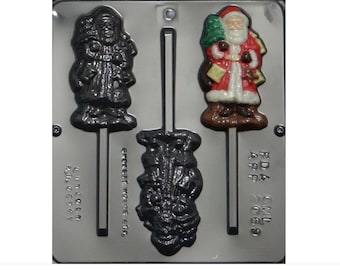 Puede incluir: Un molde de plástico para hacer piruletas de chocolate. El molde tiene tres cavidades: una con un diseño de Papá Noel, otra con un diseño de muñeco de nieve y otra con un diseño de árbol de Navidad. El molde está aprobado por la FDA y tiene el texto "CMI 2005" impreso en él.