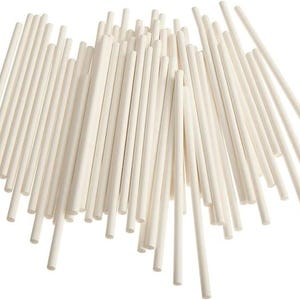 May include: A bunch of white paper lollipop sticks. The sticks are about 6 inches long and are arranged in a random pattern.