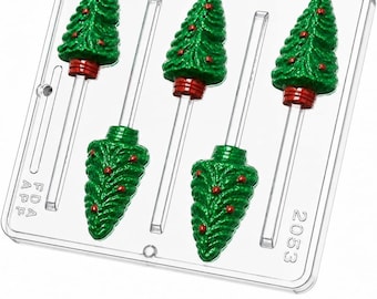 May include: A clear plastic candy mold featuring five cavities shaped like Christmas trees with integrated stick channels. The mold includes embossed text reading FDA APP and 2053. The design allows for creating tree-shaped lollipops.