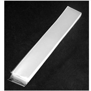 May include: A clear plastic sheet, folded in half, with a smooth, glossy finish. The sheet is lying flat on a black surface.