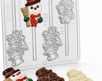 May include: A clear plastic chocolate mold featuring four cavities shaped like snowmen with top hats and brooms, accompanied by three finished chocolate lollipops in white, milk, and dark chocolate, with the text "LINCOLN" and "2060" embossed on the mold.