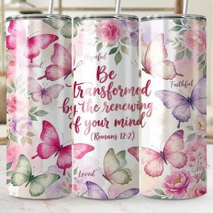 Può includere: Un bicchiere in acciaio inossidabile con un design ad acquerello di farfalle e fiori nei toni del rosa, viola e verde. Il bicchiere riporta la scritta "Be transformed by the renewing of your mind" (Romani 12:2).