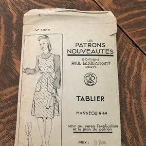 May include: A vintage sewing pattern for a polka dot apron. The pattern is from Paul Boulanger Editions, Paris, and is for a size 44. The pattern is titled "Tablier" and costs 9 Francs.