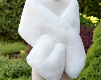 May include: White faux fur shawl, draped over a dress form, with a soft, fluffy texture.