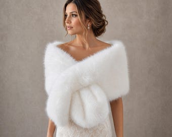 May include: A white faux fur stole draped over the shoulders. The accessory features a thick, plush texture with long, soft fibres that wrap around the upper body, providing a full, voluminous appearance across the chest and back area.