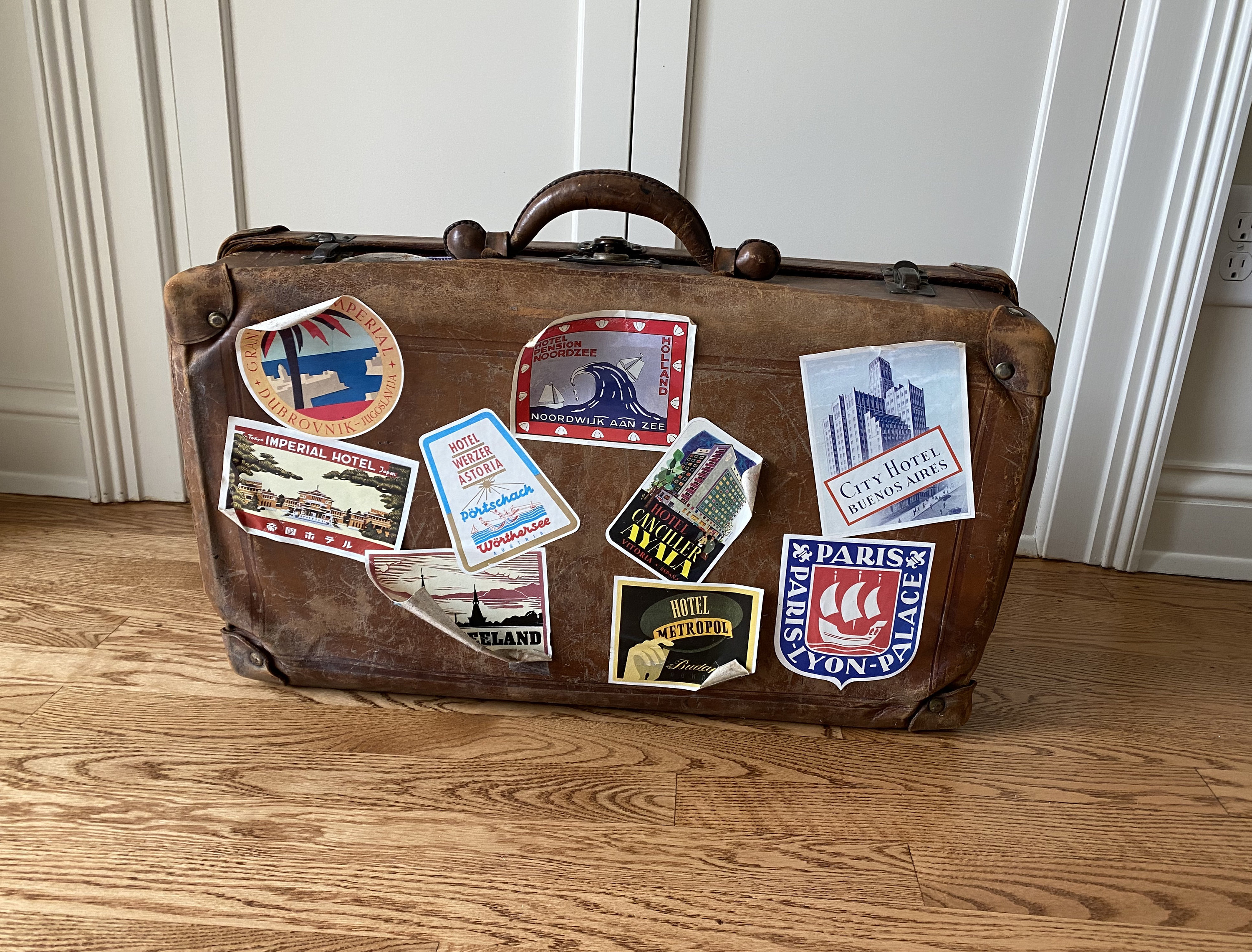 Old Suitcase Baggage With Travel Stickers Isolated On White