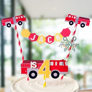 May include: A white cake with red and yellow fire truck cake toppers. The cake is decorated with a red and white striped banner that says "JACK is 4".