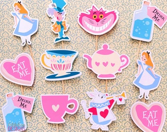 May include: Set of ten Alice in Wonderland themed cupcake toppers. The toppers feature characters from the book, including Alice, the Mad Hatter, the Cheshire Cat, and the Queen of Hearts. The toppers are printed on cardstock and have wooden sticks attached to the back.