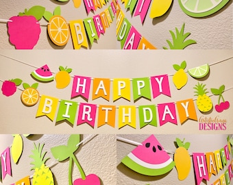 May include: A colorful Happy Birthday banner with fruit-themed decorations. The banner includes the words "Happy Birthday" in white letters on a pink, yellow, green, and orange background. The decorations include watermelon, lemons, cherries, pineapples, and oranges.