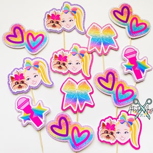 May include: A set of 10 colorful cupcake toppers featuring a popular children's entertainer, her pet dog, hearts, bows, and a microphone. The toppers are perfect for a birthday party or special occasion.
